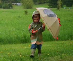 Puzzle Boy avec son parapluie et une veste imperméable sous la pluie de printemps