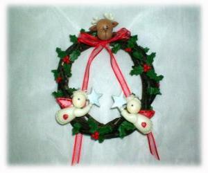 Puzzle Couronne de Noël décoré de feuilles de houx, une tête d'un renne, deux anges et d'un nœud rouge