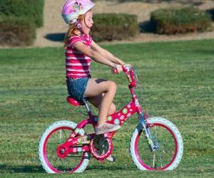 Puzzle Fille à bicyclette dans le parc au printemps