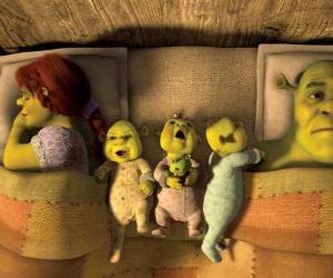 Puzzle La famille de Shrek, Fiona et trois ogres jeunes dans son lit.