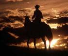 Cowboy montant un cheval ou à la tombée de la nuit