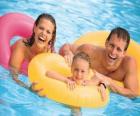 Jeune couple avec leur fille dans la piscine