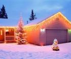 Maison décorée avec des décorations de Noël et deux arbres de Noël dans le jardin