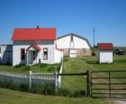 Petite ferme ou maison de ferme avec le puits à eau et son clôture