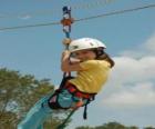 Fille aventurière saut avec une corde et harnais