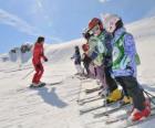 Groupe d'enfants attentifs à l'instructeur de ski