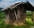 Ancienne cabane de bois au milieu du champ