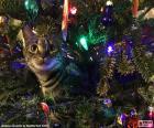 Un chat curieux parmi les décorations suspendu à l’arbre de Noël