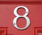Image du nombre 8, gris argent placé sur une porte rouge