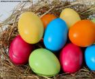 Oeufs de Pâques peint en différentes couleurs, placés dans un nid