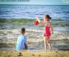 Un garçon et une fille jouant sur la plage une journée d’été