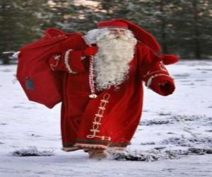 Puzzle Santa Claus transportant les gros sac de cadeaux de Noël sous la forêt